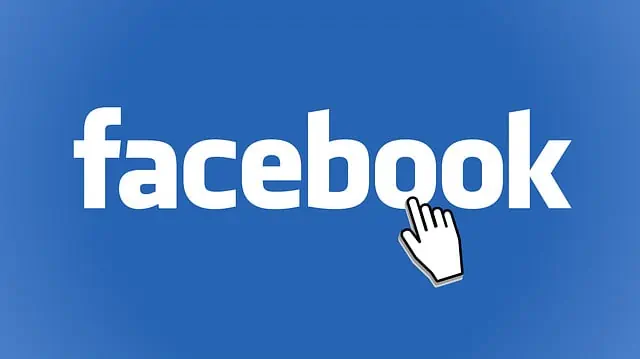 Une main touche le logo Facebook sur fond bleu dans ce guide sur la définition des budgets publicitaires Facebook.