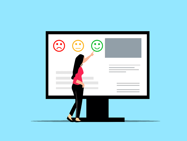 Une femme montre un écran d’ordinateur avec un visage souriant, illustrant la satisfaction du client.